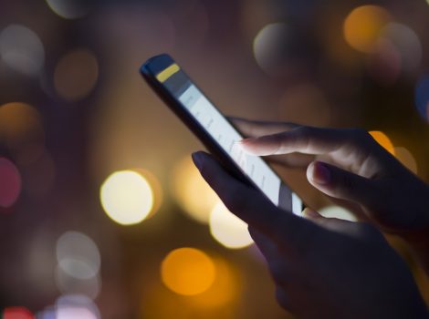 Woman using her mobile phone , city skyline night light backgro